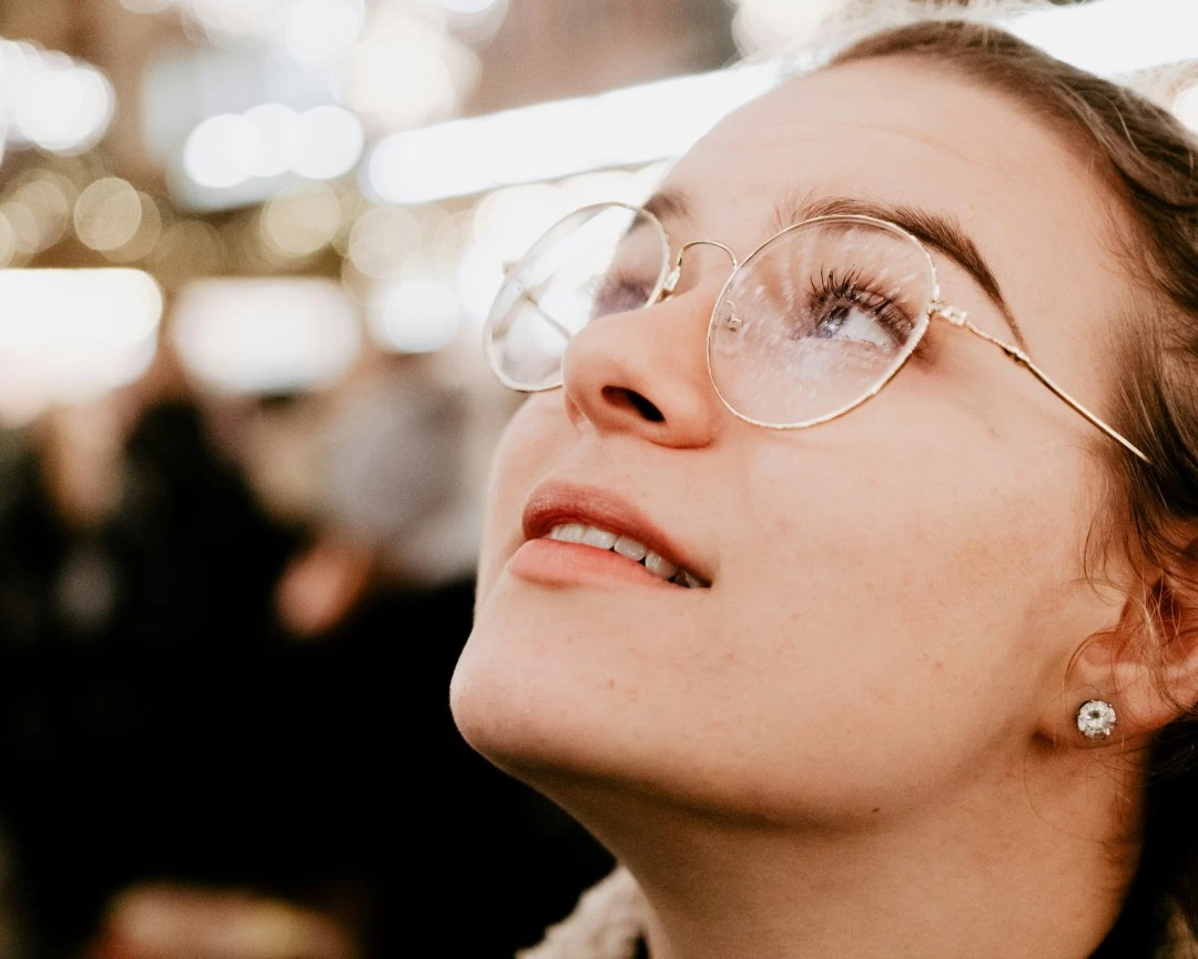 Selective focus photography of woman wearing eyeglasses looking up